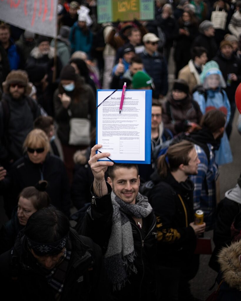 woman in black jacket holding white and green paper